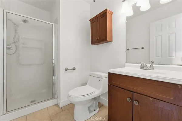 a bathroom with a toilet a sink a mirror and shower