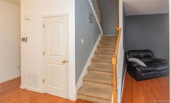 a view of a livingroom with wooden floor and stairs