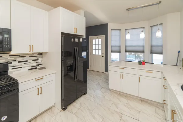 a kitchen with white cabinets and white appliances