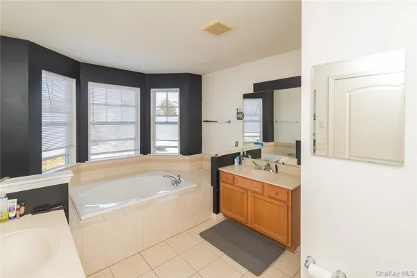 a white bath tub sitting in a bathroom next to a window