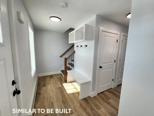 an entryway with wooden floor and staircase