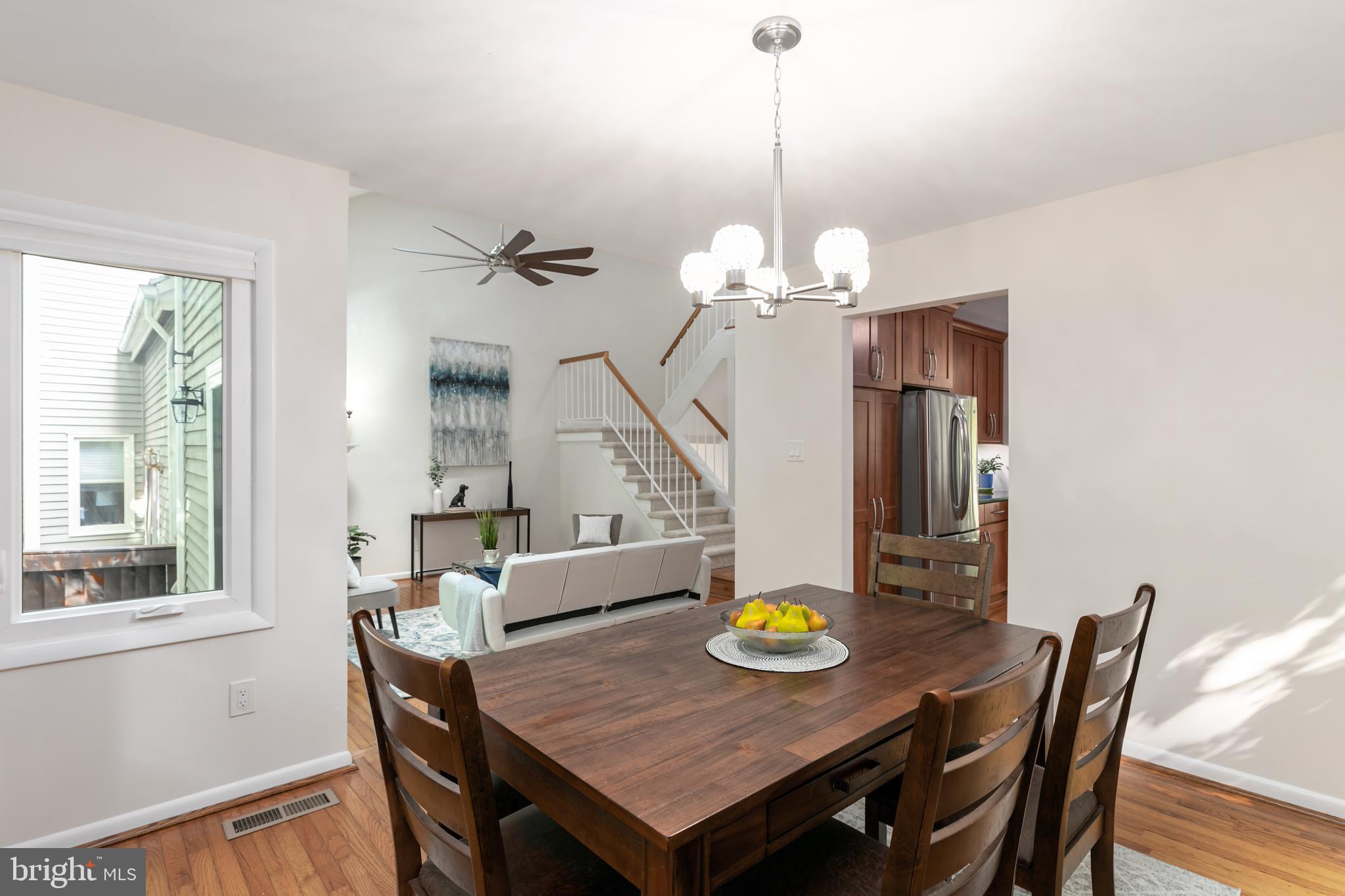 11554 Brass Lantern Court Reston, VA 20194 - Photo 11 of 47 a view of a dining room with furniture a chandelier and wooden floor