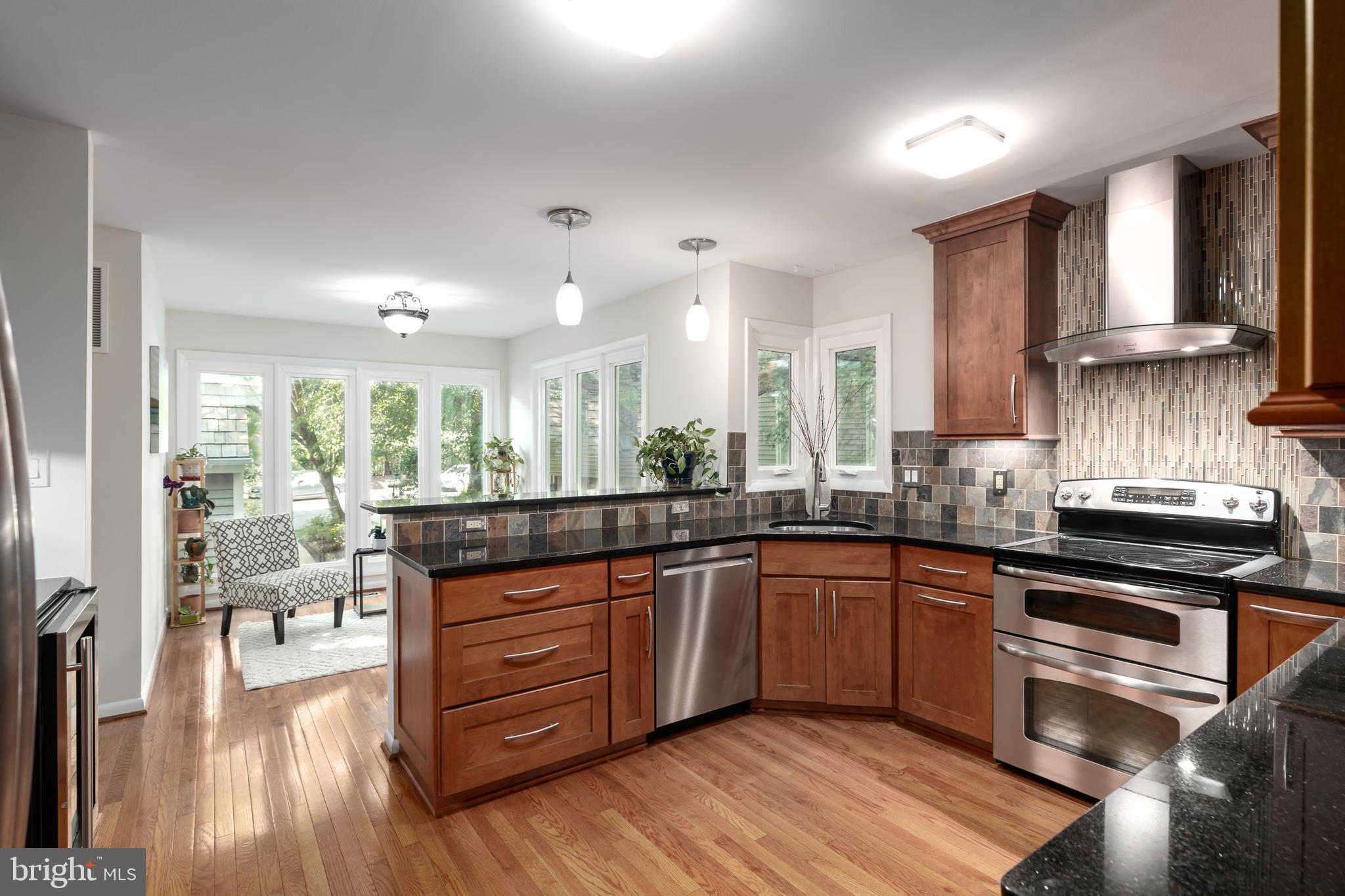 11554 Brass Lantern Court Reston, VA 20194 - Photo 3 of 47 a kitchen with stainless steel appliances granite countertop wooden floors and view living room