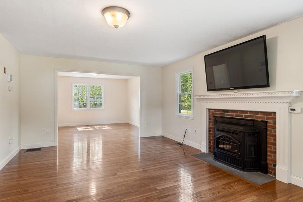 318 Great Road Shirley, MA 01464 - Photo 11 of 36 a view of an empty room with wooden floor fireplace and a window