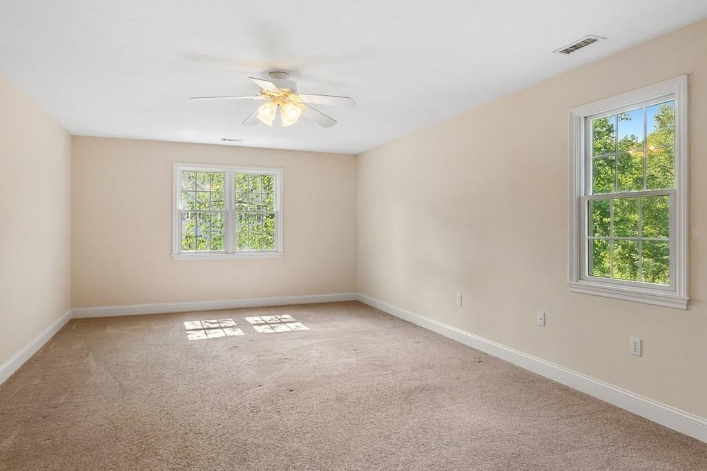 318 Great Road Shirley, MA 01464 - Photo 19 of 36 an empty room with windows and chandelier fan