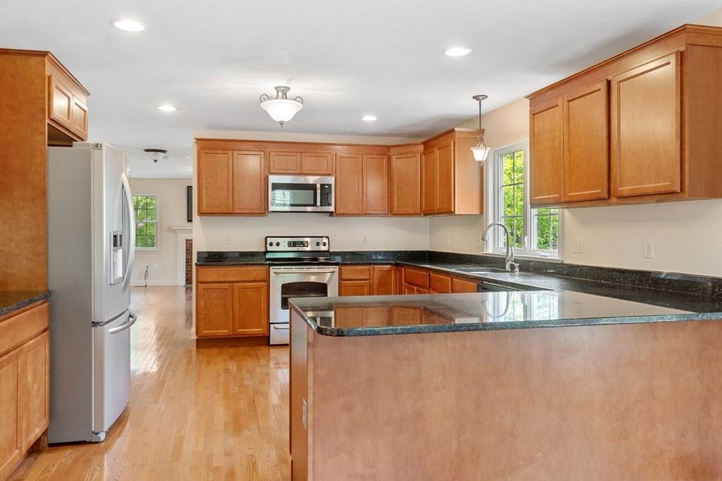 318 Great Road Shirley, MA 01464 - Photo 6 of 36 a kitchen with stainless steel appliances granite countertop a refrigerator a stove and a sink