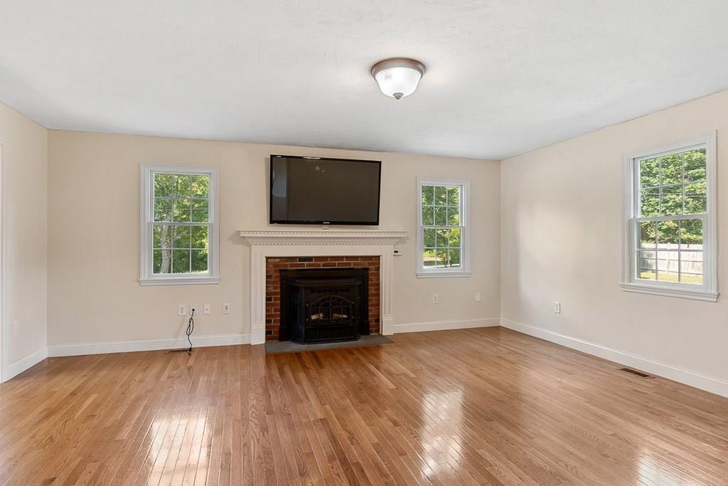 318 Great Road Shirley, MA 01464 - Photo 10 of 36 a view of empty room with a fireplace and wooden floor