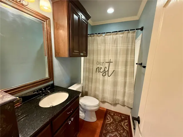 a bathroom with a granite countertop sink toilet and shower