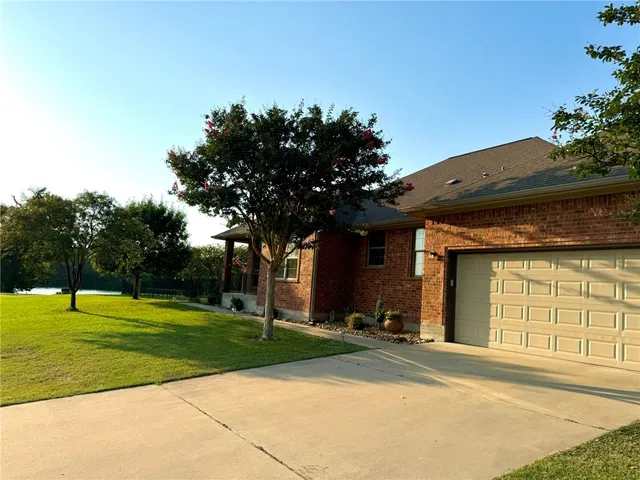 a backyard of a house with lots of green space and fountain