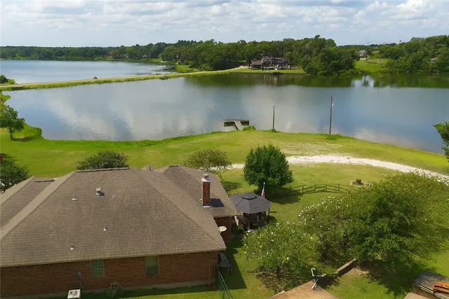 an aerial view of a house with a yard and lake view