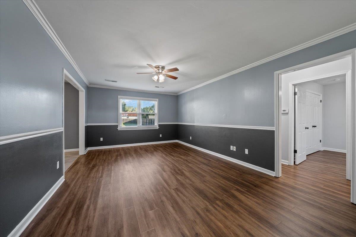 9496 Holly Grove Road Brighton, TN 38011 - Photo 7 of 29 Unfurnished room featuring crown molding, a ceiling fan, and dark wood finished floors