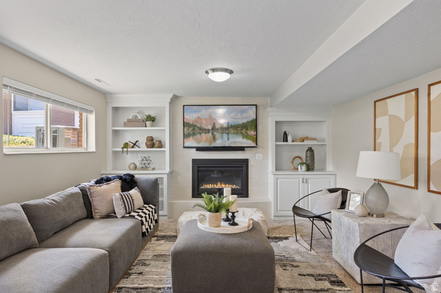 2370 Quail Run Circle East Sandy, UT 84093 - Photo 24 of 54 Living area featuring a built-in fireplace with a hearth, white built-in shelving, and recessed lighting