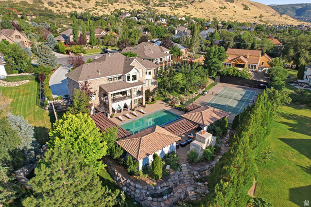 12308 Mariah Circle Draper, UT 84020 - Photo 11 of 293 2 homes on over an acre. Expansive outdoor living area featuring a large swimming pool, a full-size tennis court, a covered patio with an outdoor fireplace, and a cabana structure.