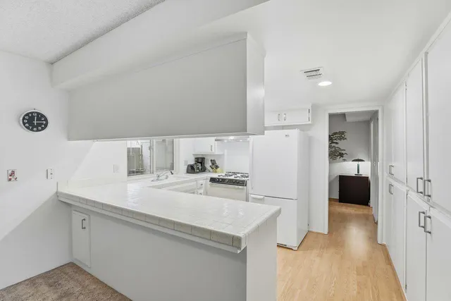 a kitchen with a refrigerator a sink and a stove top oven