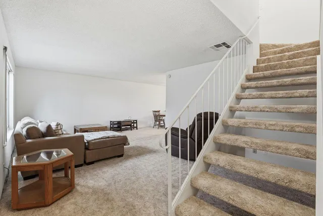 a living room with furniture and stairs