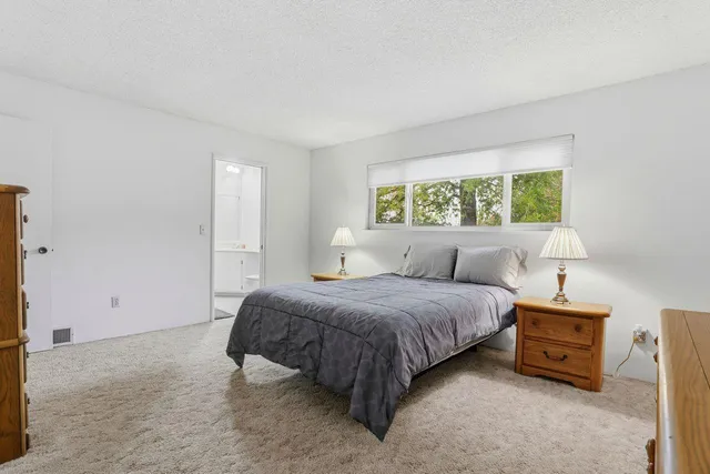 a spacious bedroom with a bed and a window