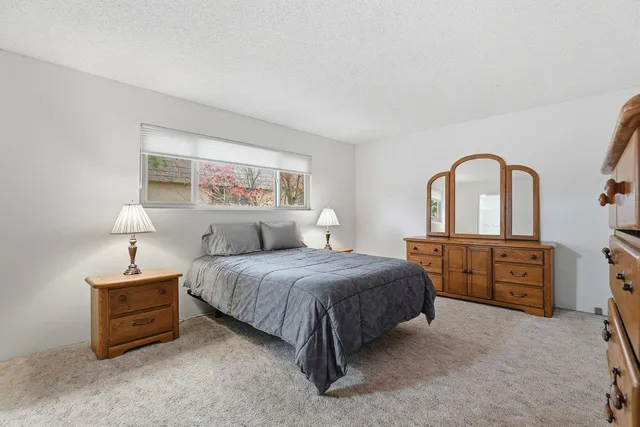 a spacious bedroom with a bed and a dresser