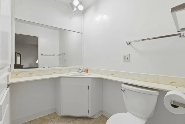 a bathroom with a toilet sink and mirror