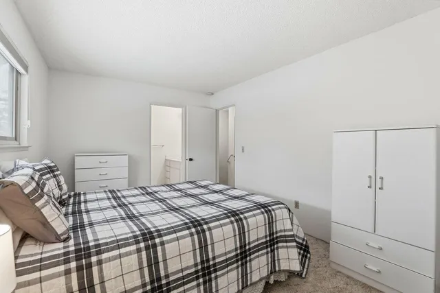 a bedroom with a bed and white cabinets