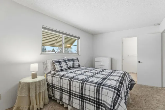 a bedroom with a bed a table and chair