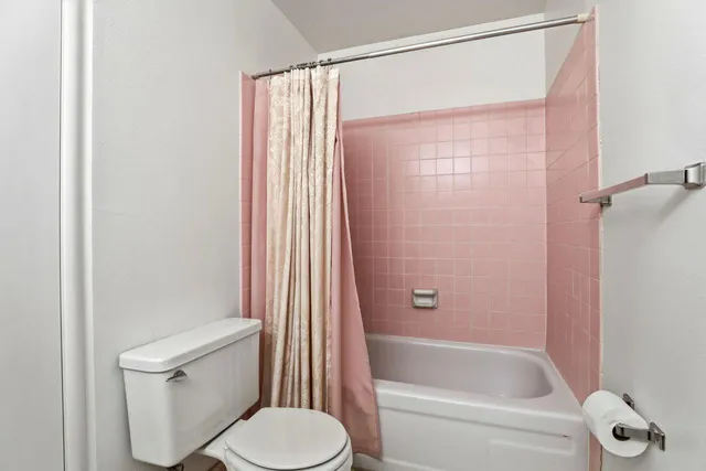 a white toilet sitting next to a bath tub