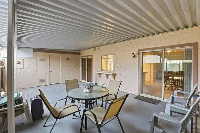 a outdoor dining space with a table and chairs