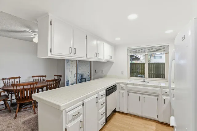 a kitchen with granite countertop white cabinets and white appliances