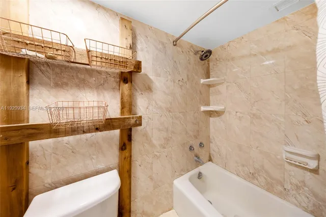 a front view of a building with lot of cars and trees