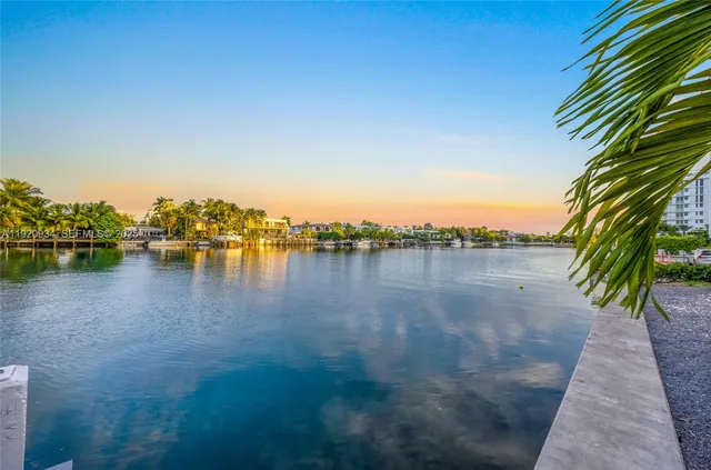 an aerial view of ocean and residential houses with outdoor space