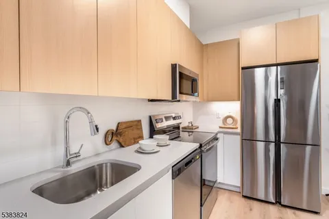 a kitchen with a refrigerator sink and white cabinets