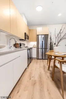 a kitchen with stainless steel appliances a sink cabinets and wooden floor