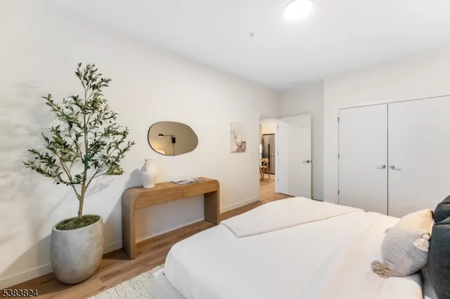 a bedroom with a large bed and a potted plant