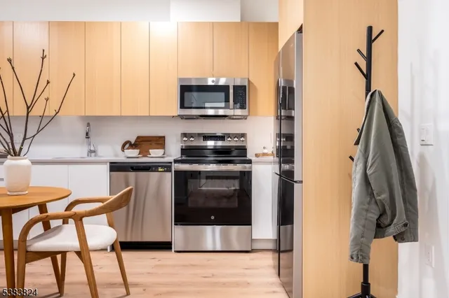 a kitchen with stainless steel appliances a stove a sink and a refrigerator