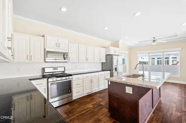 a kitchen with stainless steel appliances granite countertop a sink stove and refrigerator