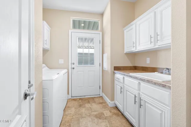 a kitchen with white cabinets and sink