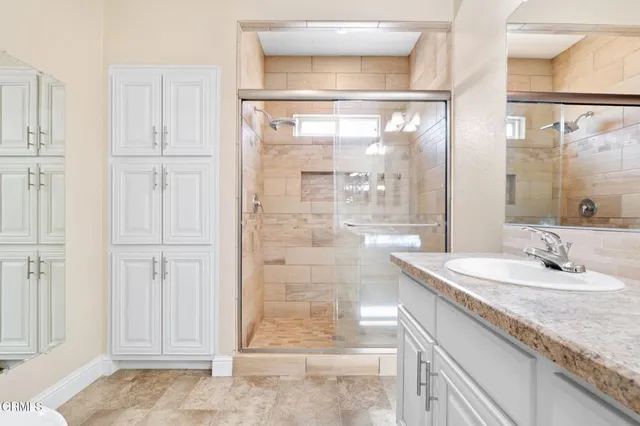 a bathroom with a granite countertop sink and a mirror
