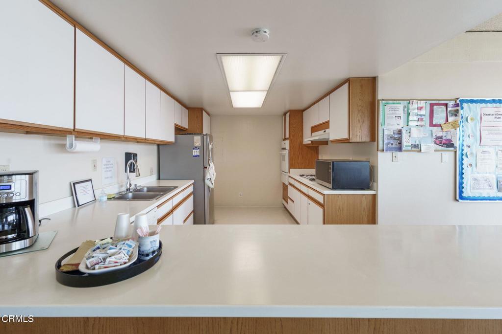 5540 West 5th Street, Unit 1 Oxnard, CA 93035 - Photo 34 of 35 a kitchen with stainless steel appliances kitchen island granite countertop a stove and a refrigerator