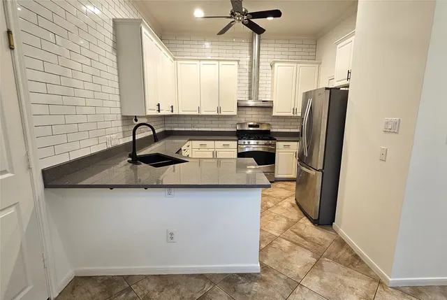 a kitchen with stainless steel appliances granite countertop a sink a refrigerator and a stove