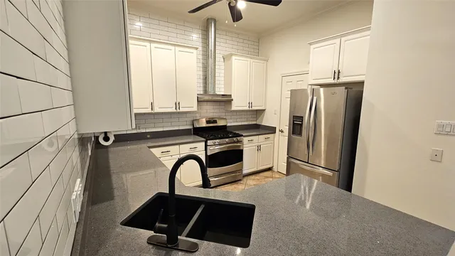 a kitchen with stainless steel appliances a refrigerator sink and cabinets