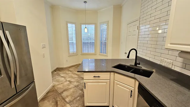 a kitchen with granite countertop a sink and a refrigerator