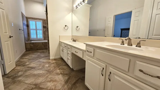 a spacious bathroom with a double vanity sink a mirror and a shower