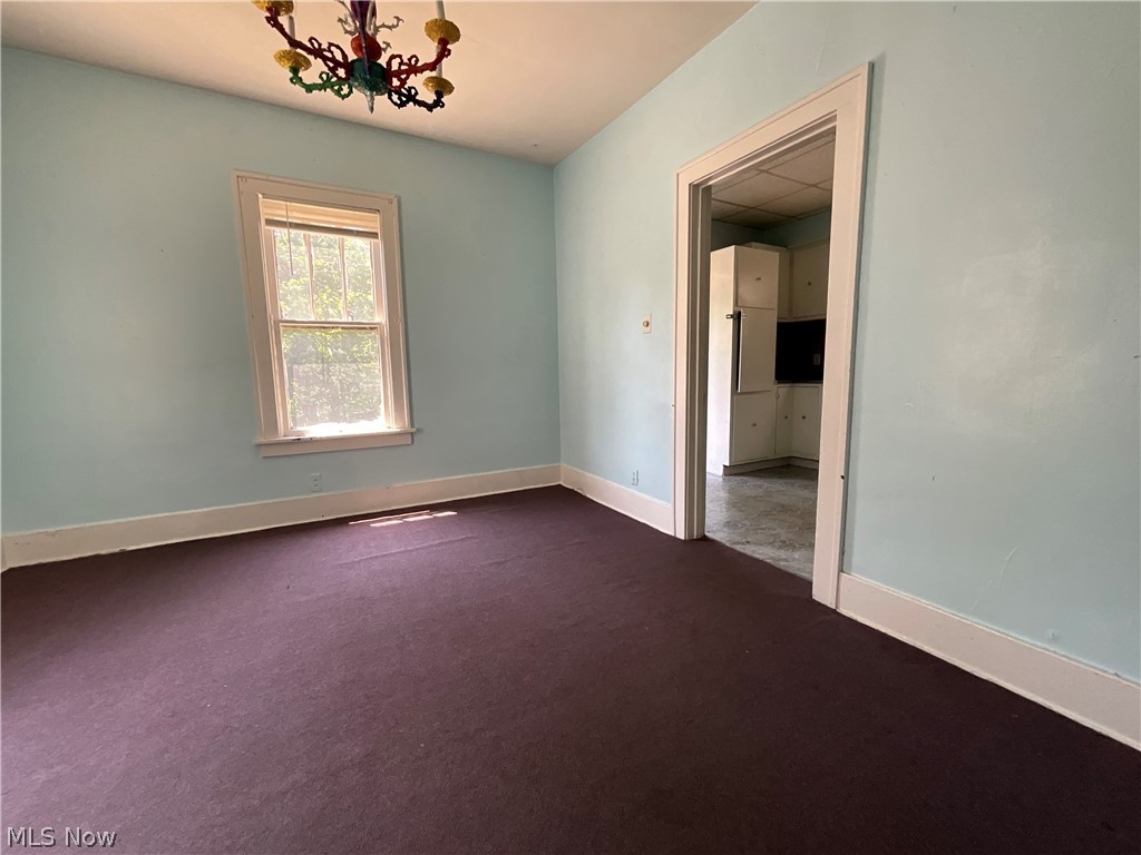 700 Cove Road Weirton, WV 26062 - Photo 10 of 26 Spare room featuring a notable chandelier and dark carpet