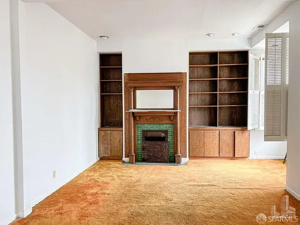 a view of an empty room with a fireplace and a window