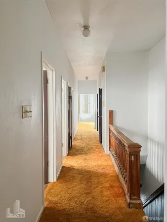 a view of a hallway with wooden floor and windows