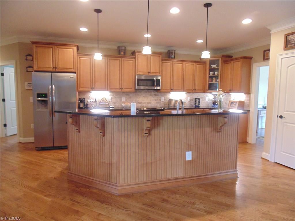 8192 Rylan Drive Browns Summit, NC 27214 - Photo 7 of 21 This gorgeous kitchen offers designer maple cabinetry, tiled backsplash, granite counter, separate pantry, and a breakfast bar!