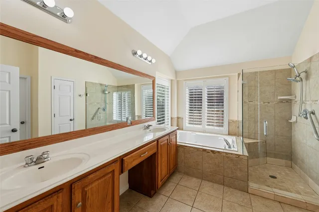 a spacious bathroom with a granite countertop tub sink shower and mirror