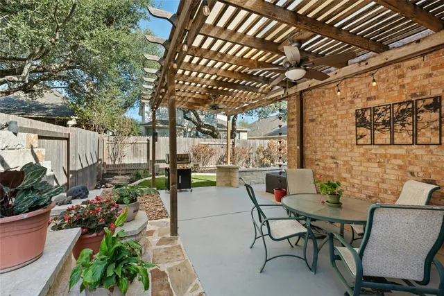 a view of a patio with table and chairs potted plants and large tree