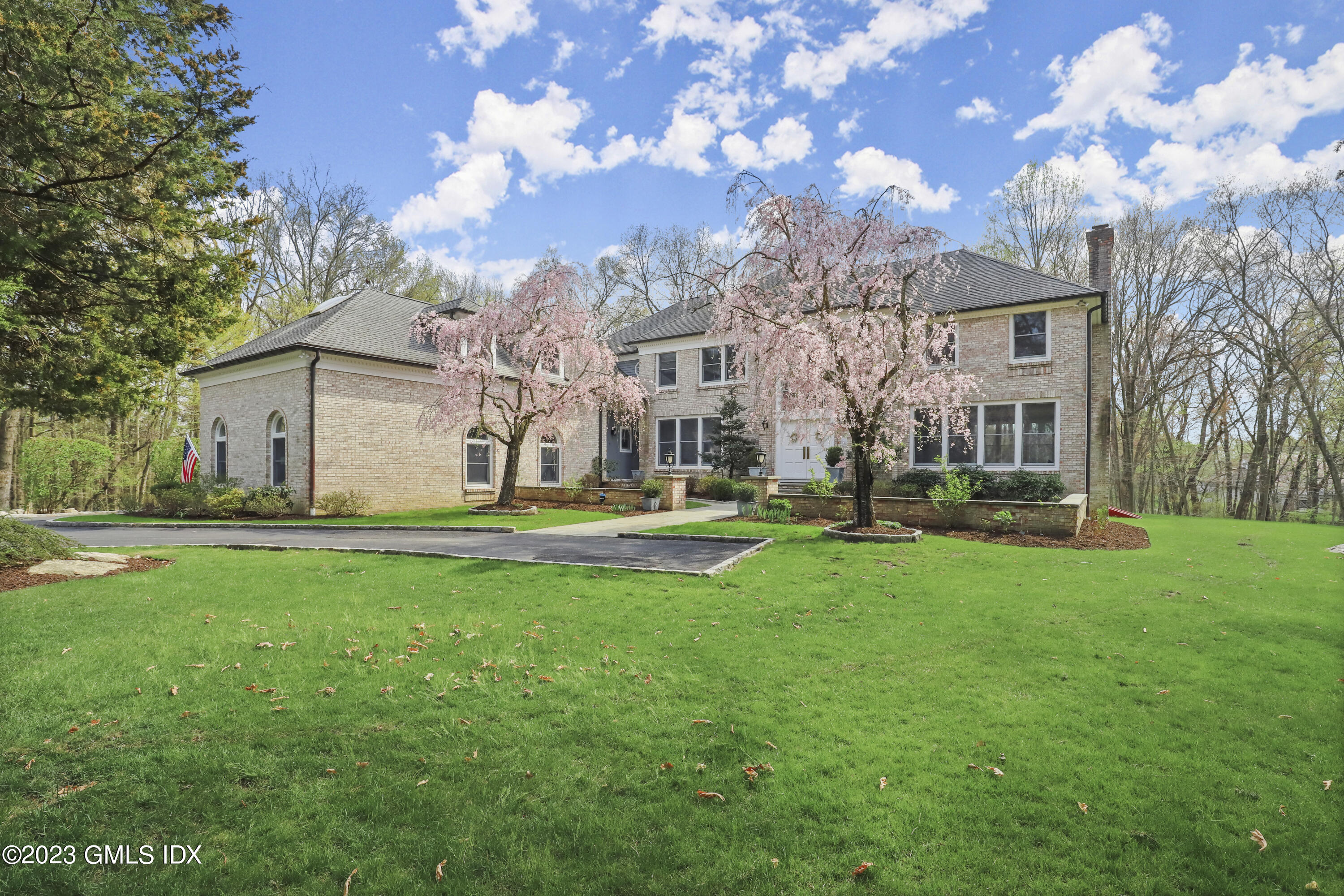 12 Juniper Hill Road Greenwich, CT 06830 - Photo 1 of 61 a view of a white house with a big yard and large trees