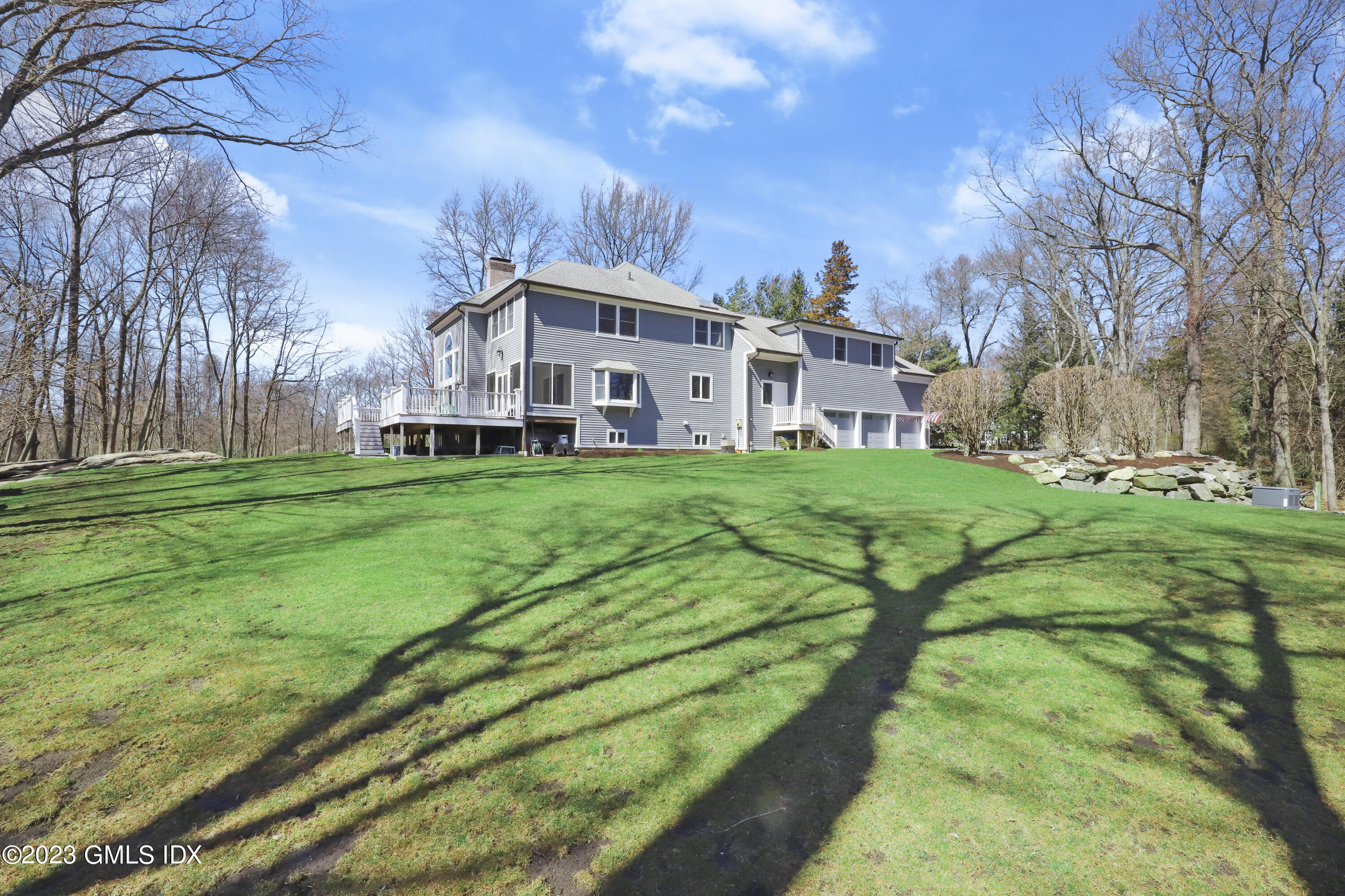 12 Juniper Hill Road Greenwich, CT 06830 - Photo 54 of 61 a view of a white house with a big yard and large trees