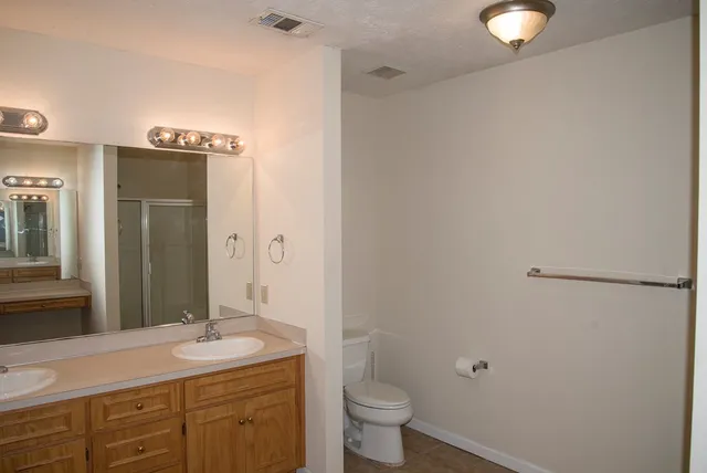 a bathroom with a granite countertop sink toilet and shower
